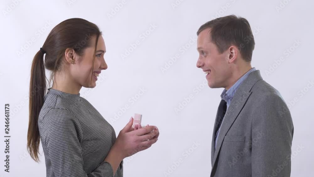 Beautiful young woman open a present box to a man and show guy her present , male very happy with gift hug his wife and super happy isolated on white background in studio. Beautiful young woman open a present box to a man and show guy her present , male very happy with gift hug his wife and super happy isolated on white background in studio.