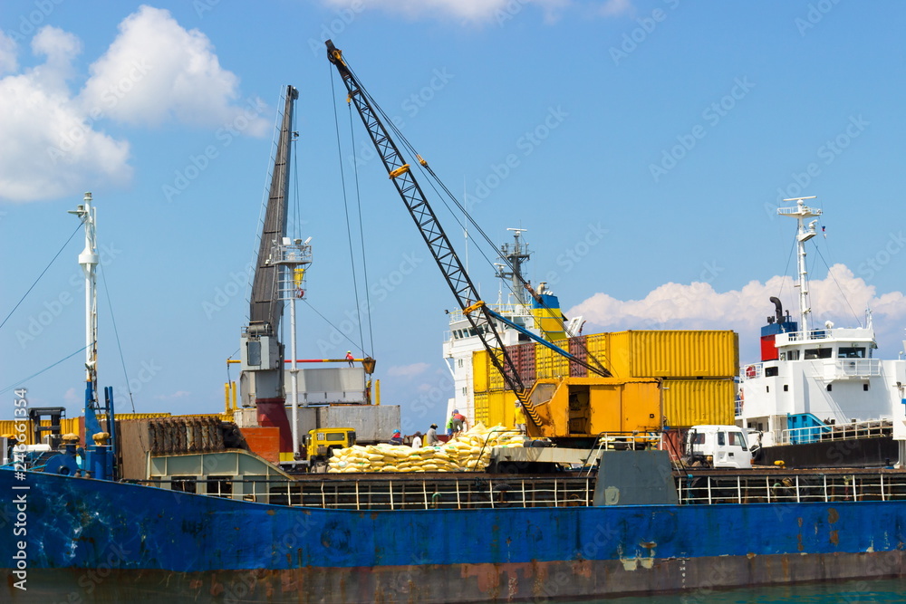 Loading or unloading works in commercial port at Cebu, Philippines a bright sunny day. Cargo transportation concept
