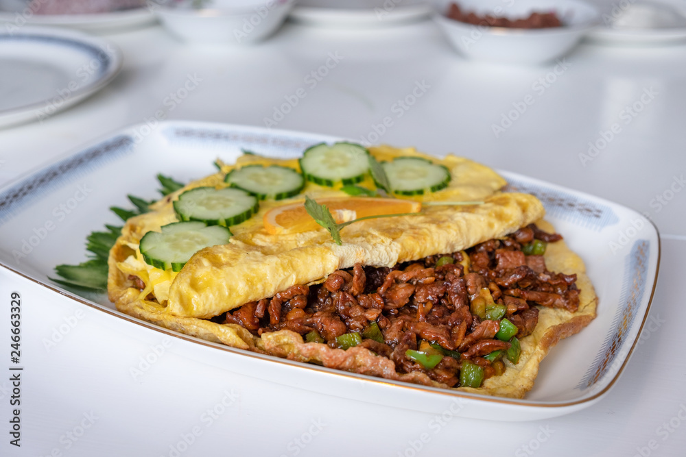 Omelet filled beef fried with vegetable on white table Omelet filled beef fried with vegetable on white table