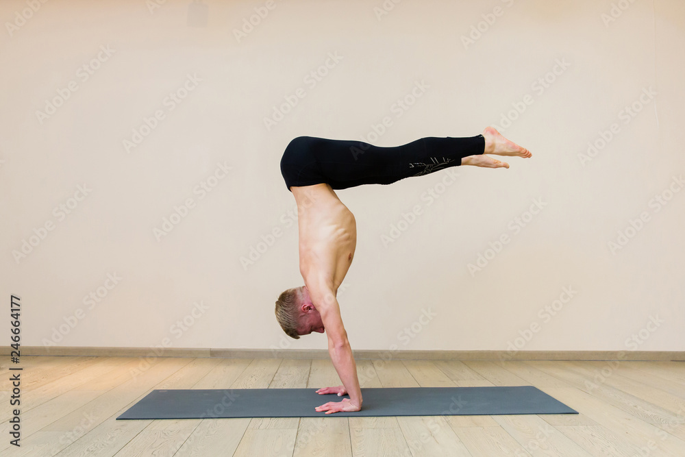 Sporty man practicing yoga on yoga class