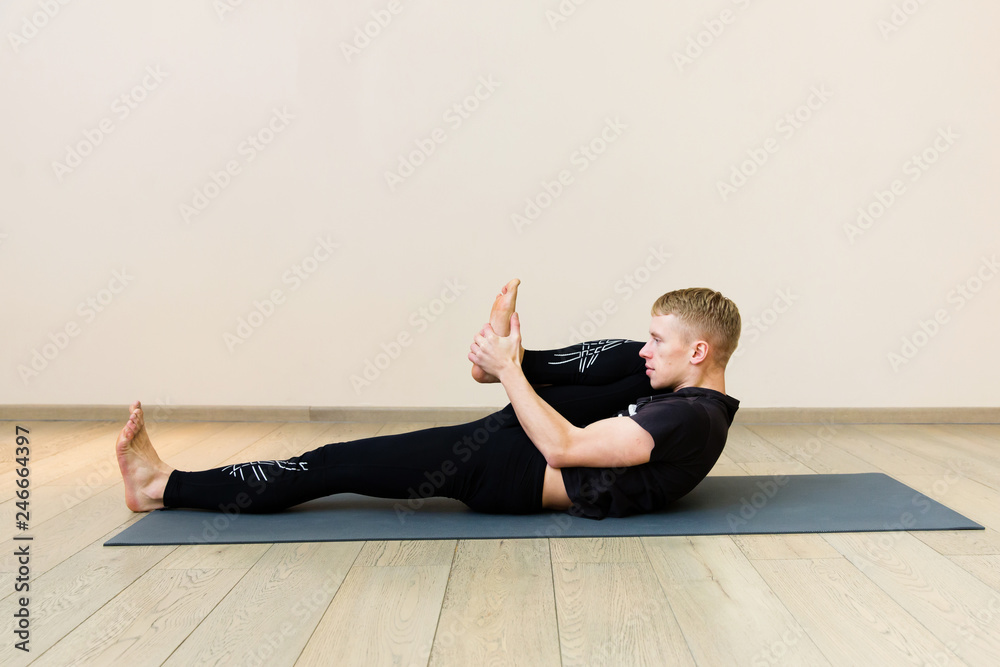 Sporty man practicing yoga on yoga class