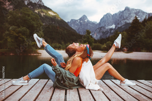 Konstfotografi Two young tourist women have fun on the dock on lake