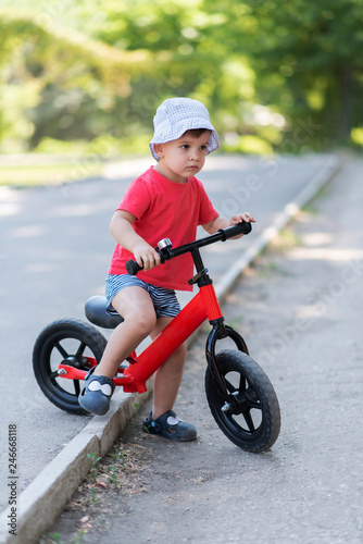 little kid riding a bicycle without pedals summer © johnalexandr