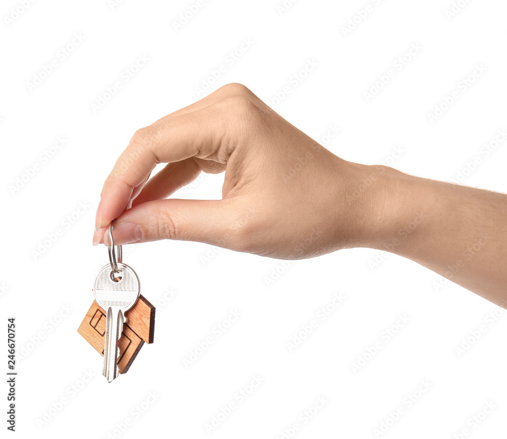 Fototapeta premium Woman holding house key with trinket on white background, closeup