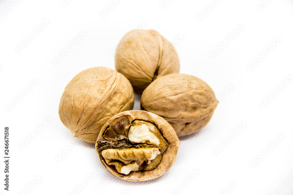 a few walnut in shell and peeled on white background a few walnut in shell and peeled on white background