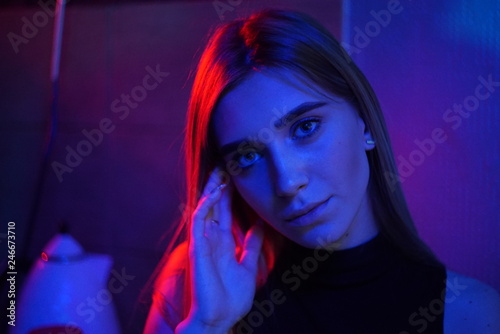 Sexy young beauty woman posing over night city dramatic red and blue neon background