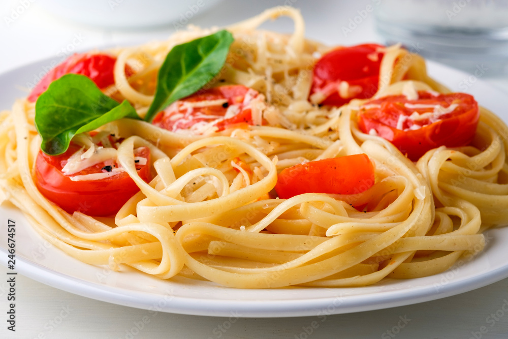 Pasta spaghetti with tomato sauce and cheese parmesan served on dark plate on table background