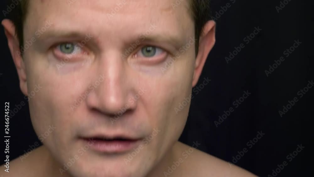 man sneezing on a black background. Portrait of sneezing man.