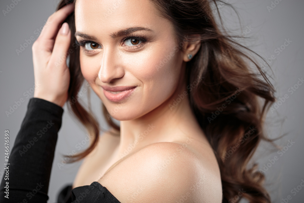 Brunette girl with healthy curly hair and natural make up . Beautiful model woman with wavy hairstyle .Care and beauty Brunette girl with healthy curly hair and natural make up . Beautiful model woman with wavy hairstyle .Care and beauty