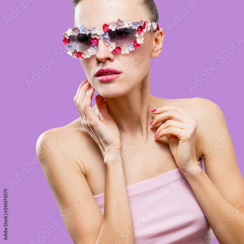 Beautiful summer woman wearing sunglasses over violet purple background