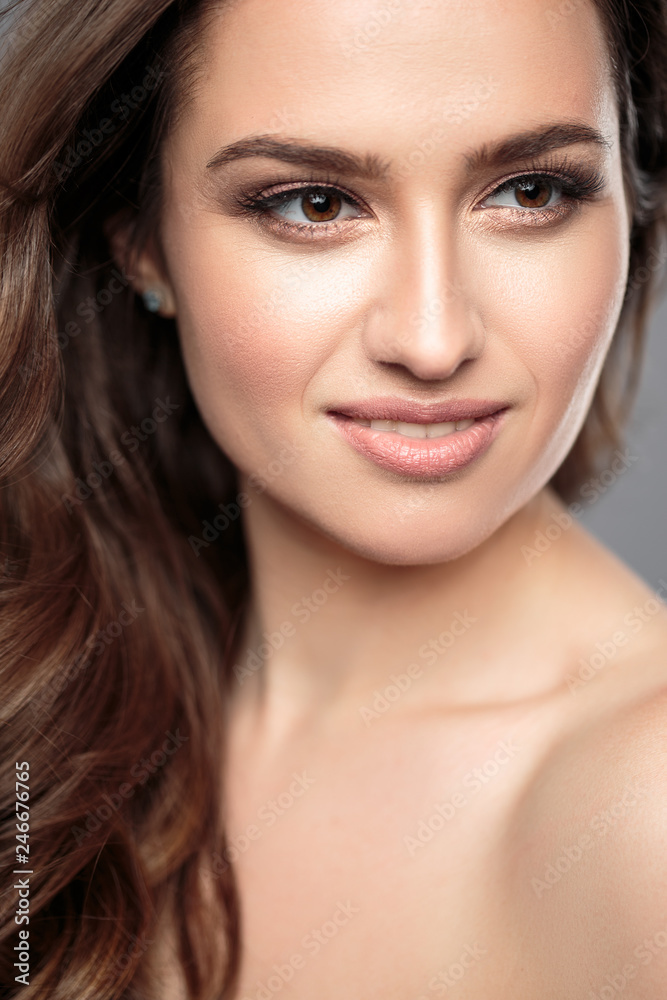 Brunette girl with healthy curly hair and natural make up . Beautiful model woman with wavy hairstyle .Care and beauty Brunette girl with healthy curly hair and natural make up . Beautiful model woman with wavy hairstyle .Care and beauty