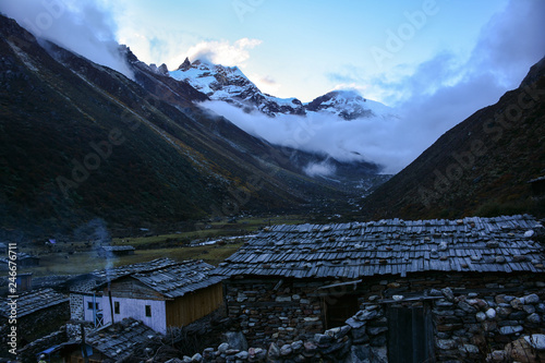 Beautiful evening view of Himalayan ridge from Khambachen at dusk. Traditional nepalese stone houses on the foreground. Kangchenjunga, Nepal photo