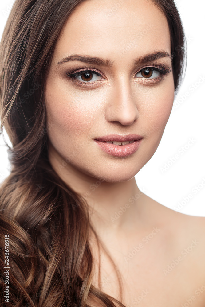 Brunette girl with healthy curly hair and natural make up . Beautiful model woman with wavy hairstyle .Care and beauty