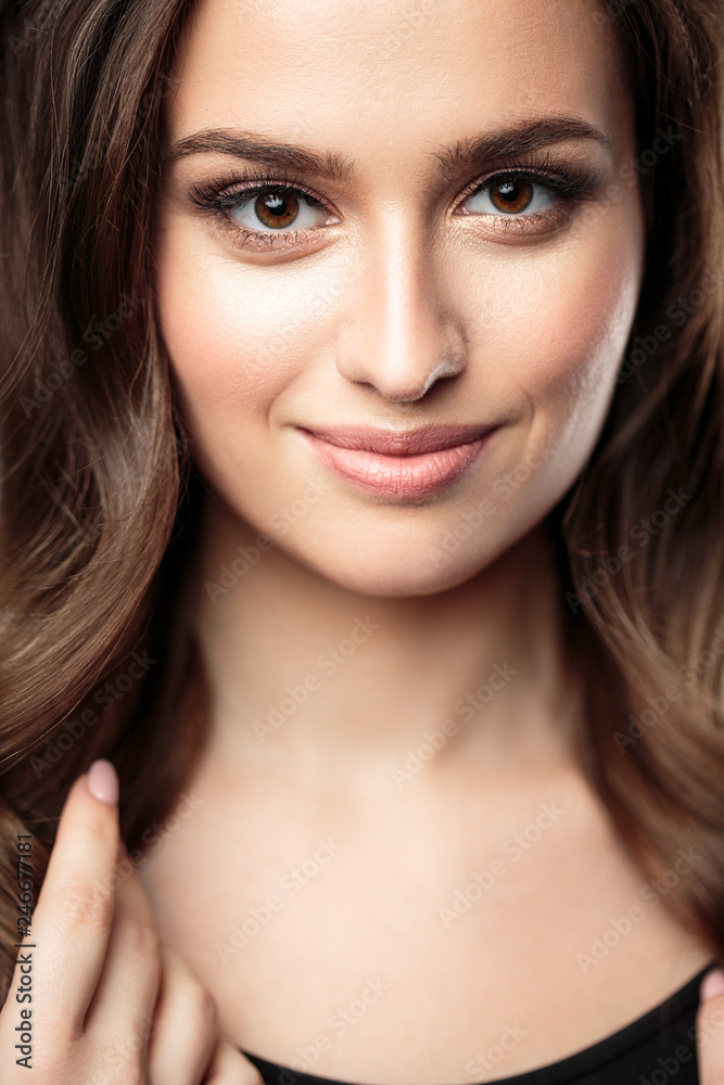 Brunette girl with healthy curly hair and natural make up . Beautiful model woman with wavy hairstyle .Care and beauty Brunette girl with healthy curly hair and natural make up . Beautiful model woman with wavy hairstyle .Care and beauty