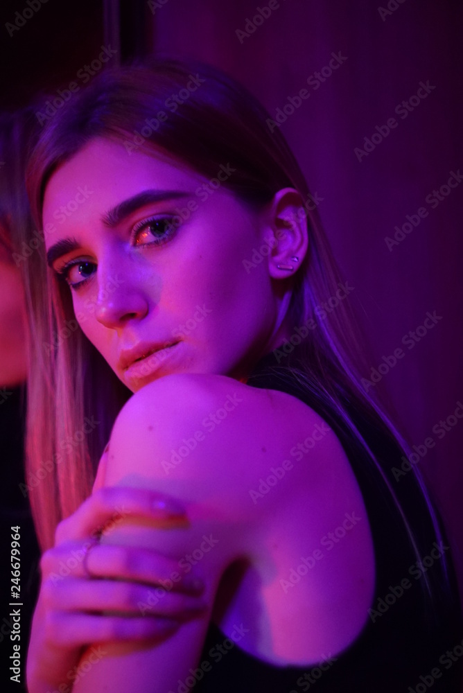 Fototapeta premium Sexy young beauty woman posing over night city dramatic red and blue neon background