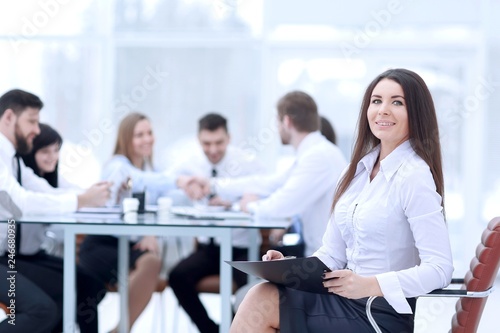 business woman signing a business document with its background blurred office