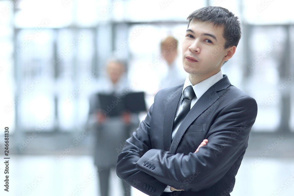 close up.confident young businessman on blurred office background close up.confident young businessman on blurred office background
