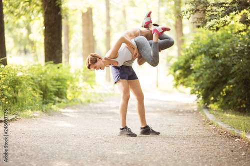 Young beautiful couple stretching in park
