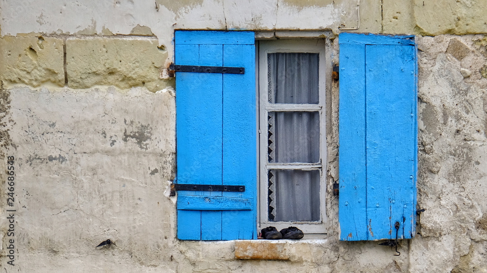 Altes Fenster mit blauen Läden