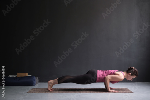 Woman practicing yoga, standing in chaturanga dandasana exercise