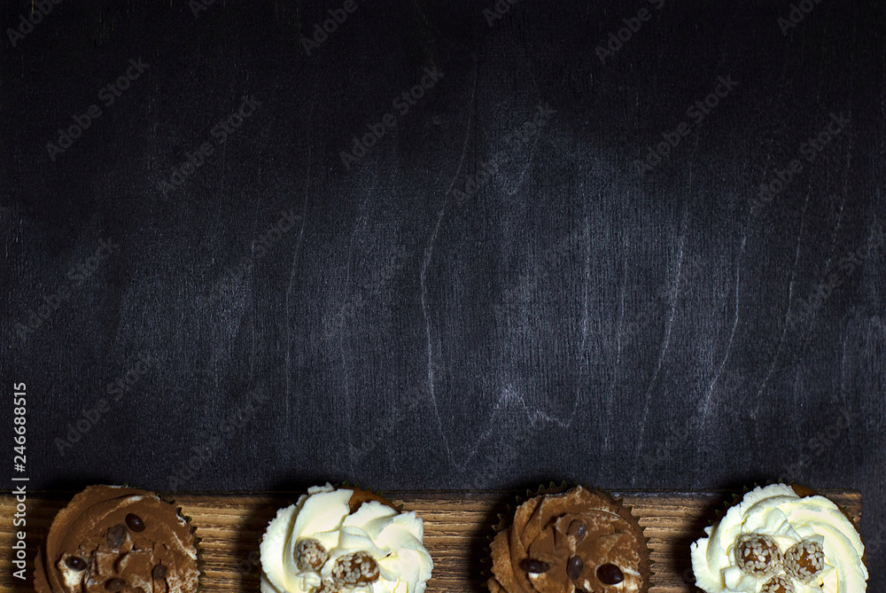 lighted cupcakes on a wooden board against a black background lighted cupcakes on a wooden board against a black background