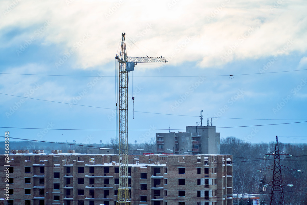 Construction crane on the city background at sunset time Construction crane on the city background at sunset time