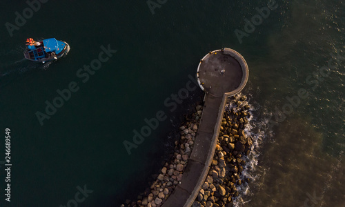 Pier at the entrance to the harbor in Helsingborg, Sweden during sunset from above.  © Viktorishy
