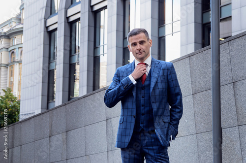 Bild auf Leinwand Charismatic man in a plaid suit on the background of the business center (office)