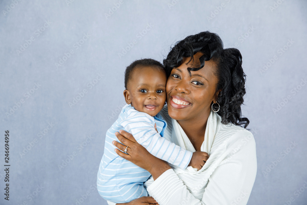Beautiful African Amercian Woman wHolding Her Baby boy on a Gray Background Beautiful African Amercian Woman wHolding Her Baby boy on a Gray Background