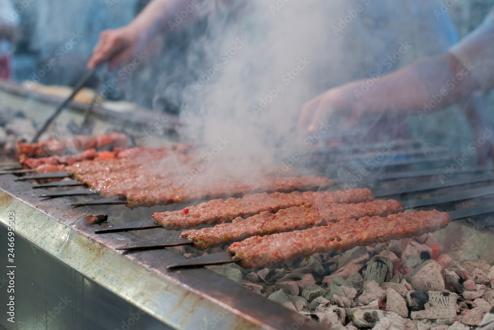 Kebab or kebap meat shish on metal skewer barbecue and embers in the kebab restaurant. Skewering bbq Kebab. Traditional Turkish Adana Kebab Kebab or kebap meat shish on metal skewer barbecue and embers in the kebab restaurant. Skewering bbq Kebab. Traditional Turkish Adana Kebab