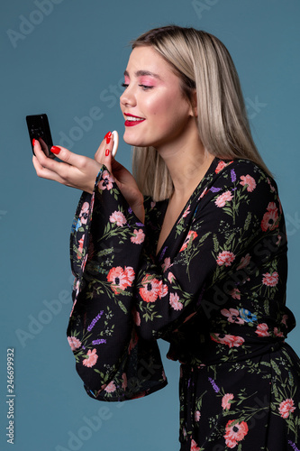 Pretty young woman face powder applying makep