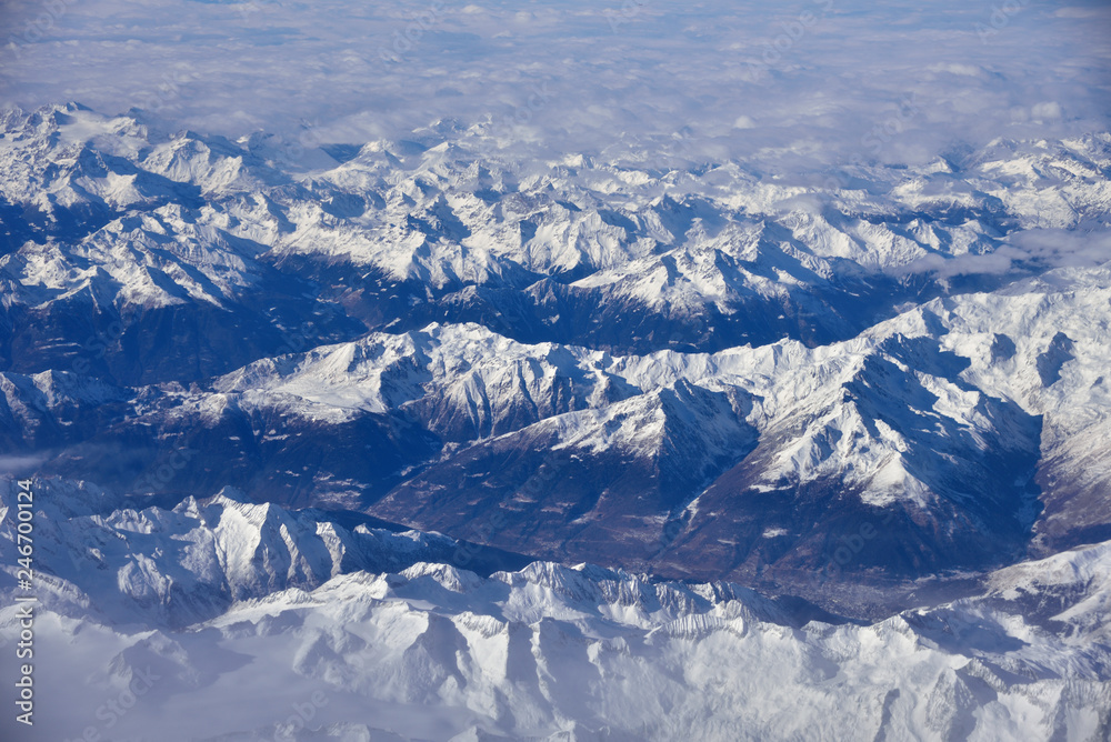 Fototapeta premium Aerial view of the rugged snow covered mountains of the Alps at the junction of Italy, France and Switzerland 