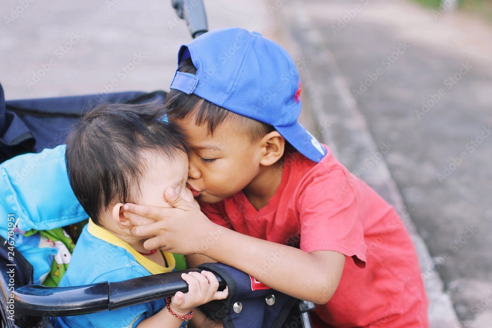 Family and love concept, a young brother kiss a baby sister. 