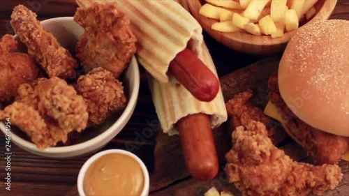 Delicious but unhealthy food with ketchup and mustard on vintage cutting board. Fast carbohydrates, junk and fast food. Warm wooden background