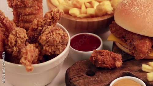 Delicious but unhealthy food with ketchup and mustard on vintage cutting board. Fast carbohydrates, junk and fast food. Warm wooden background