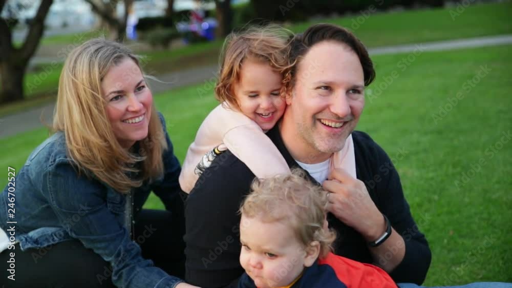 Cheerful family hugging outdoor.