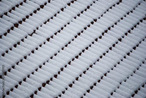 Abstract pattern of snow covered roof tiles 