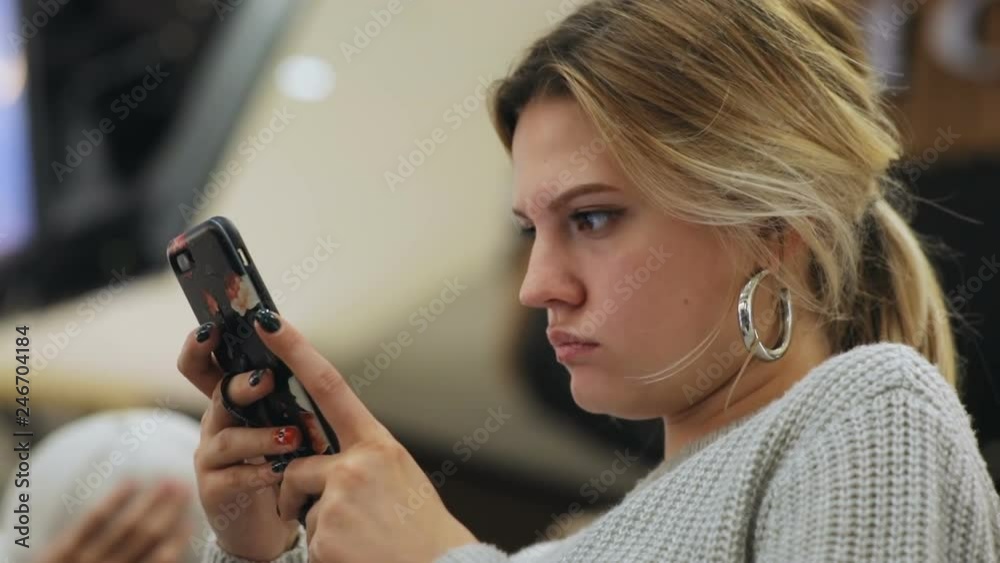Nice airline passenger waiting for flight plane. Portrait of good-looking Caucasian girl using gadget in waiting room of airport. Indoors. Vacation concept. Nice airline passenger waiting for flight plane. Portrait of good-looking Caucasian girl using gadget in waiting room of airport. Indoors. Vacation concept.