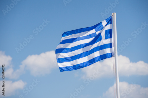 White blue Greece flag on white pylon with blue sky with cloud