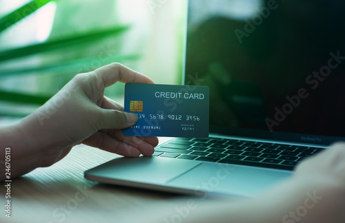 Business and financial concepts. Asian businesses hold credit cards for online purchases via mobile phones, laptops and pay with online banking via credit cards - images.