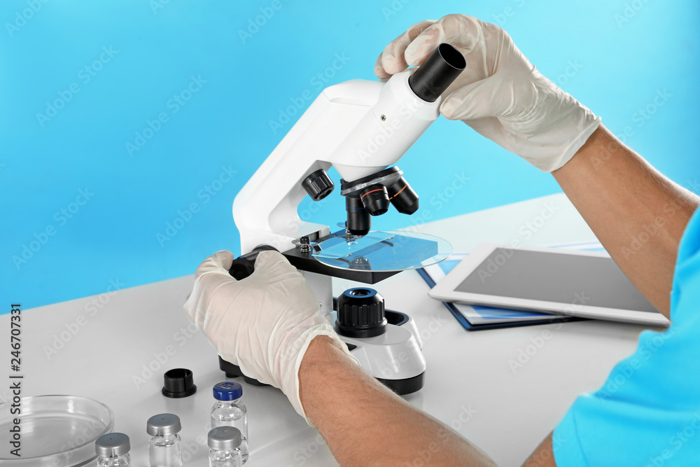 Male doctor using microscope at table, closeup. Medical object Male doctor using microscope at table, closeup. Medical object
