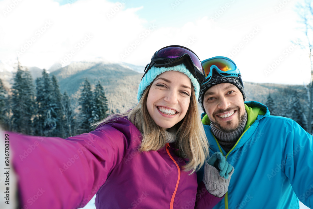 Happy couple taking selfie during winter vacation in mountains Happy couple taking selfie during winter vacation in mountains