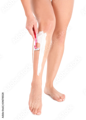 Beautiful young woman shaving leg on white background  closeup view