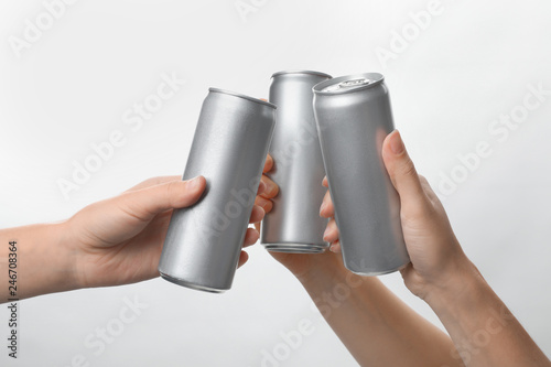 People holding aluminum cans on white background, closeup. Space for design