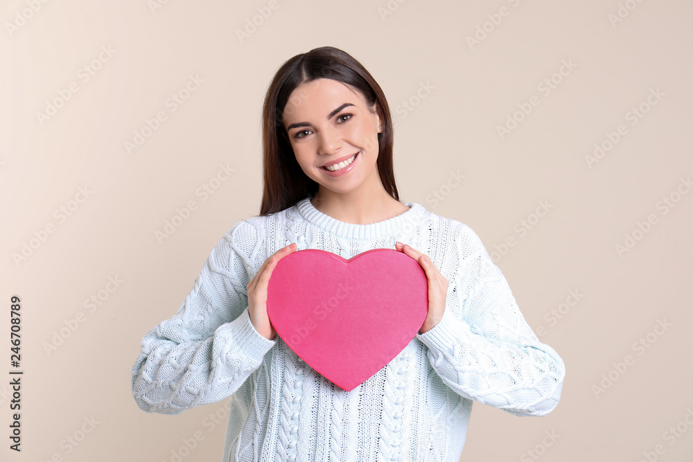 Portrait of young woman with decorative heart on color background Portrait of young woman with decorative heart on color background