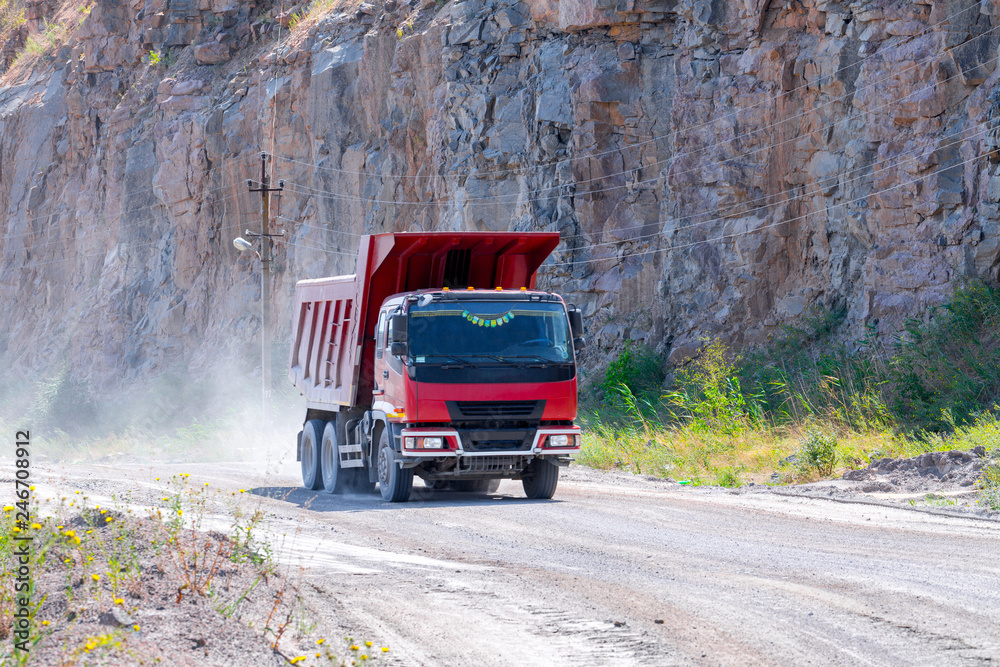A dump truck loaded mined granite in a quarry open pit mining of granite stone. Process production stone and gravel. Quarry mining equipment.