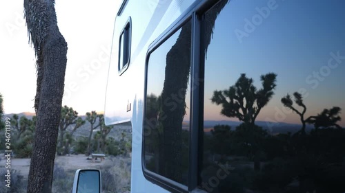 Reflection of Joshua trees in window of Recreational Vehicle. Camping in Black Rock Campground, Joshua Tree National Park, California, USA. Handheld shot with stabilized camera. photo