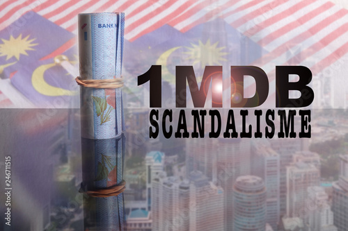 1 Malaysian Ringgit banknotes with incription 1MDB over a blur background of Malaysia flags and cityscape.