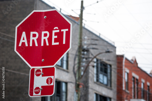 Quebec Stop Sign, obeying by bilingual rules of the province imposing the use of French language on roadsigns, thus translated Stop into Arret, taken in the streets of Montreal, Canada © Jerome
