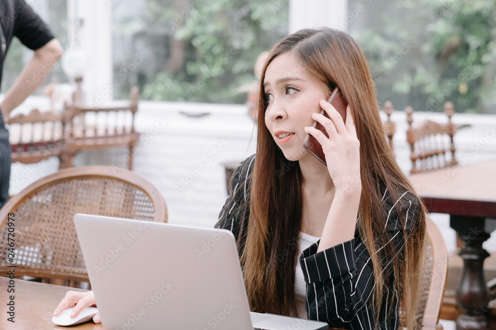 Side view portrait of young businesswoman having business call in office, her workplace, writing down some information. Woman talking on mobile phone, asking questions, looking at pc screen. Side view portrait of young businesswoman having business call in office, her workplace, writing down some information. Woman talking on mobile phone, asking questions, looking at pc screen.